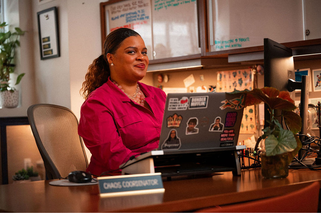 An Adler University admissions coordinator smiles while sitting at her desk.