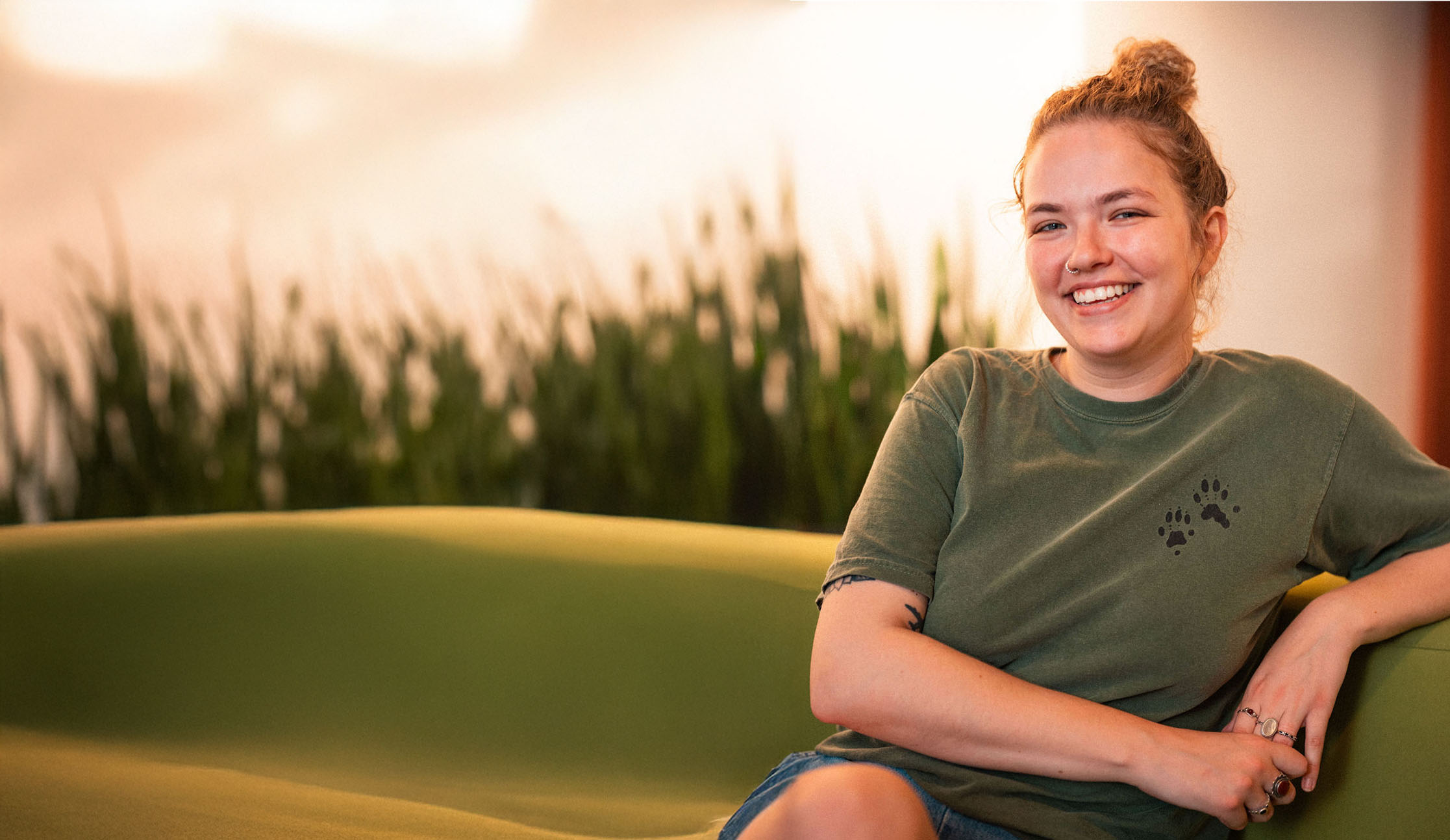 An Adler University student smiles while sitting on a couch at the Chicago campus.